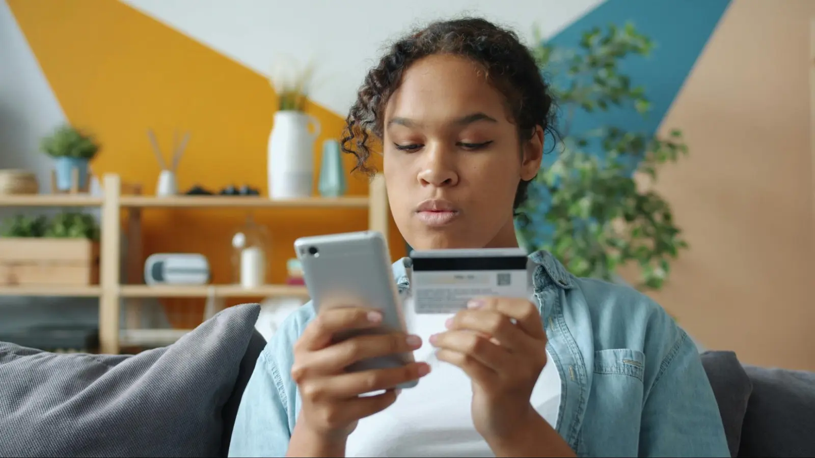Acheteuse qui paie en ligne avec sa carte de crédit sur son téléphone pendant le Vendredi fou